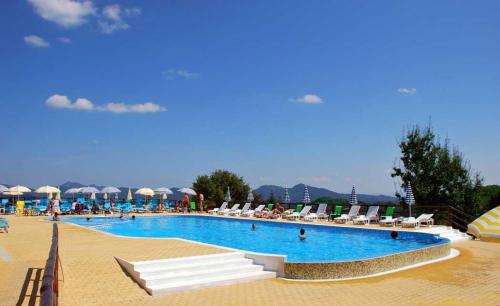 a large swimming pool with chairs and umbrellas at Panorama Family Hotel in Zlatograd