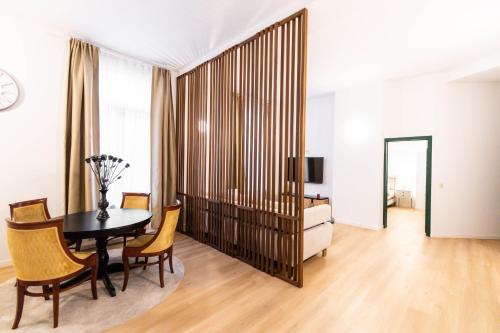 a dining room with a table and chairs and a television at Gotha Aparthotel in Brussels