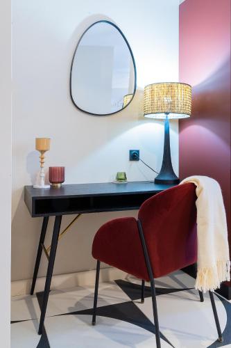 a desk with a red chair and a mirror at Host Inn Bien-être SPA JACUZZI Downtown in Lyon