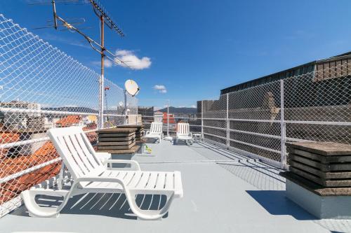 a group of white chairs sitting on top of a roof at Ático Dúplex con Terrazas Privadas Vigo Centro 2 hab ツ by Rias Baixas Rentals in Vigo