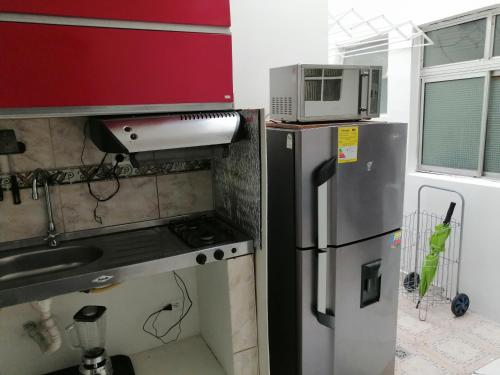 a kitchen with a stove and a microwave at usoinmobiliario in Medellín
