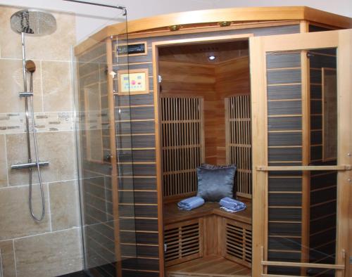 a shower stall with a seat in a bathroom at Duo Détente in Le Chenoy