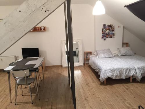 a bedroom with a bed and a desk and a table at Les Gîtes Du Pays De Charleroi in Charleroi