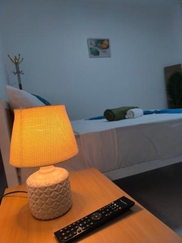 a lamp sitting on a table next to a remote control at Plateau Bedroom & Chambre - Praia Center 1 in Praia