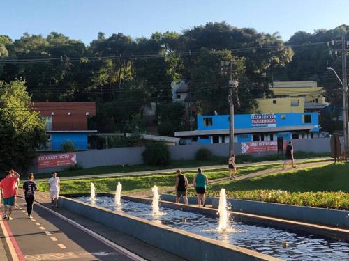 a group of people walking in front of a fountain at Apto 27 Flamingo in Pato Branco