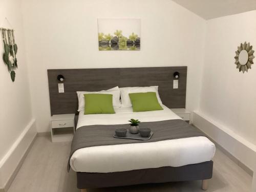 une chambre avec un grand lit avec des oreillers verts dans l'établissement Appartement Altea 85 m2 climatisé parking proche Sanctuaires, à Lourdes
