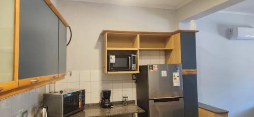 a kitchen with a refrigerator and a microwave at Tigre Centro Cochera Gratis in Tigre