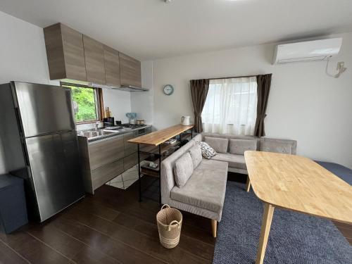 a kitchen and living room with a couch and a table at ココナッツ屋久島 in Yakushima