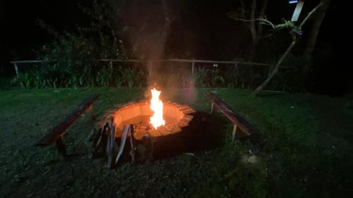 a fire pit in the grass at night at Cabañita del bosque de la cumbre de san Bartolo Milpas Altas in Guatemala