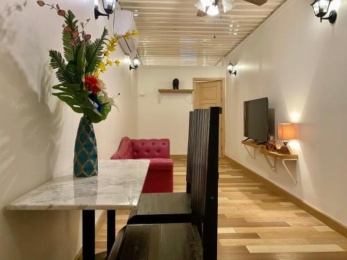 a living room with a vase of flowers on a table at Happy Land Residence in Ban Nam Cham