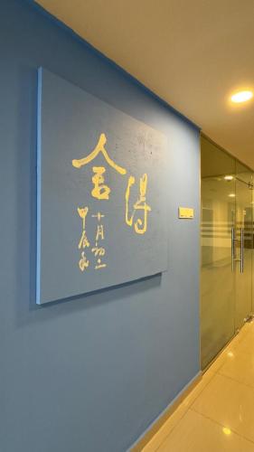a sign on a blue wall in a building at South of The Clouds HOTEL KL Sentral 吉隆坡彩云之南酒店-中央车站店 in Kuala Lumpur