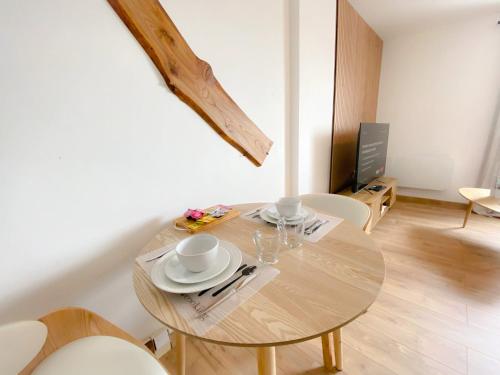 une table avec deux tasses et des assiettes dessus dans une pièce dans l'établissement Le Côte d'Opale, à Calais