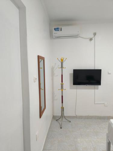 a white room with a mirror and a television at Plateau Bedroom & Chambre - Praia Center 1 in Praia