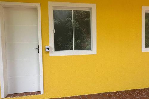 a yellow house with a door and a window at Apto 104 Flamingo, 1P, Único in Pato Branco