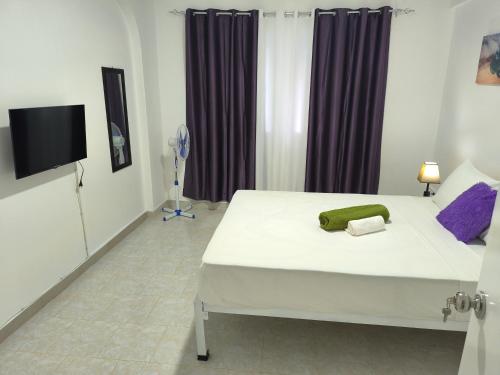 a bedroom with a bed and a flat screen tv at Plateau Bedroom & Chambre - Praia Center 1 in Praia