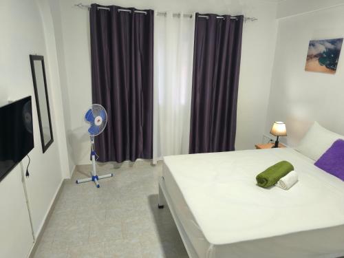 a bedroom with a bed with a green pillow on it at Plateau Bedroom & Chambre - Praia Center 1 in Praia