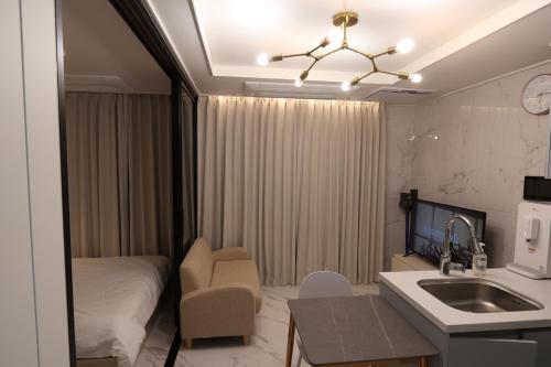 ソウルにあるCity Hall,Central Seoul apartmentのベッド、シンク、キッチンが備わる客室です。