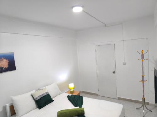 a living room with a white couch and a cross on the wall at Plateau Bedroom & Chambre - Praia Center 1 in Praia
