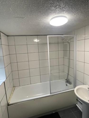 a bathroom with a tub and a sink at Close to Central in Luton