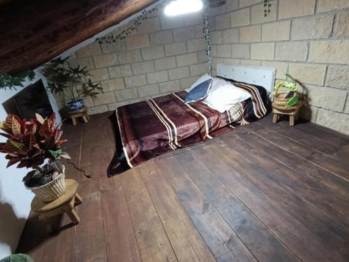 ウアスカ・デ・オカンポにあるCabaña Conde Eidrienのレンガの壁にベッド1台が備わるベッドルーム1室