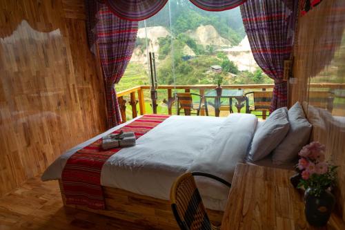 a bed in a room with a large window at Truong Nhan Tram Tau Homestay in Cham Ta Lao