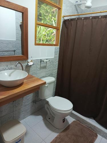 a bathroom with a toilet and a sink at CABAÑAS GOLDEN TANAGER in Mindo