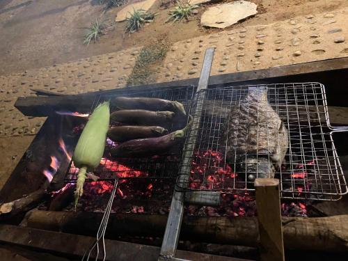 a grill with a bunch of hot dogs on it at Truong Nhan Tram Tau Homestay in Cham Ta Lao