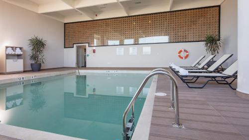 a swimming pool with chairs in a building at Holiday Inn & Suites - Aguascalientes by IHG in Aguascalientes