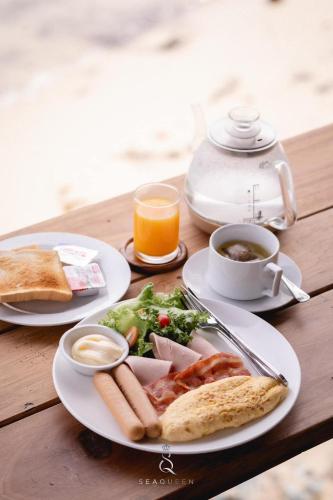 een tafel met twee borden eten en een kop koffie bij SEAQUEEN The Pool ,Koh Samed in Ko Samed