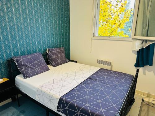 - une chambre avec un lit doté d'oreillers violets et d'une fenêtre dans l'établissement ALEJÒ-HOME, Séjour apaisant!, à La Croix-de-Berny