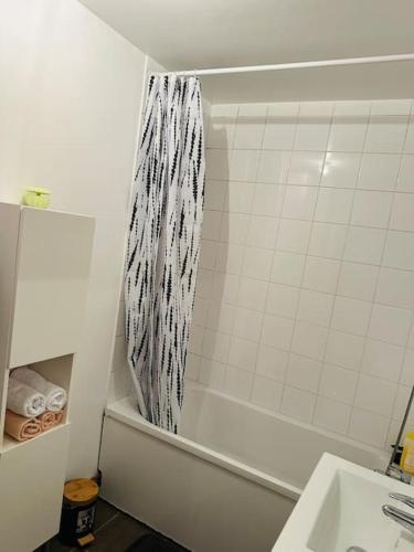 La salle de bains est pourvue d'un rideau de douche à côté d'un lavabo. dans l'établissement ALEJÒ-HOME, Séjour apaisant!, à La Croix-de-Berny