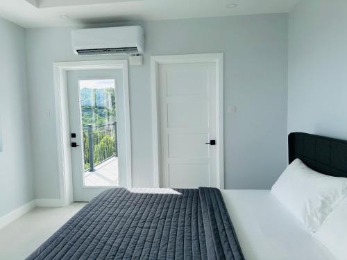 a white bedroom with a bed and a window at The Luxury Escape in Rouarné