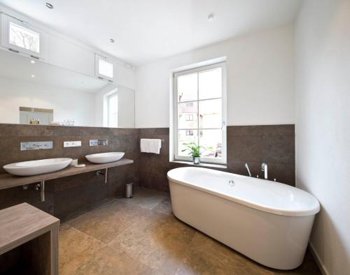 a large bathroom with two sinks and a tub at Konventchen in Aschaffenburg