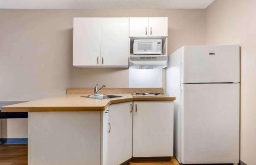 a kitchen with white cabinets and a white refrigerator at Extended Stay America Suites - Fort Worth - City View in Fort Worth