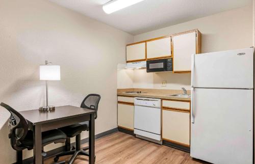 a small kitchen with a table and a refrigerator at Extended Stay America Suites - Cincinnati - Blue Ash - Reed Hartman in Blue Ash