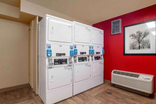 a room with four white washers and a red wall at Extended Stay America Suites - Orange County - Lake Forest in Foothill Ranch