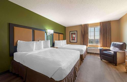 a hotel room with two beds and a chair at Extended Stay America Suites - Minneapolis - Airport - Eagan - North in Eagan