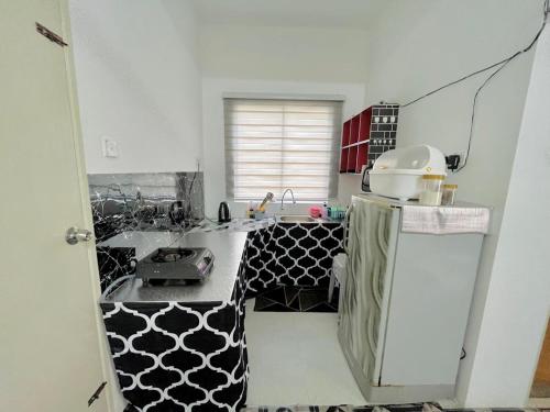 una pequeña cocina con encimera en blanco y negro en Homestay Keboon Rantau Panjang, en Rantau Panjang