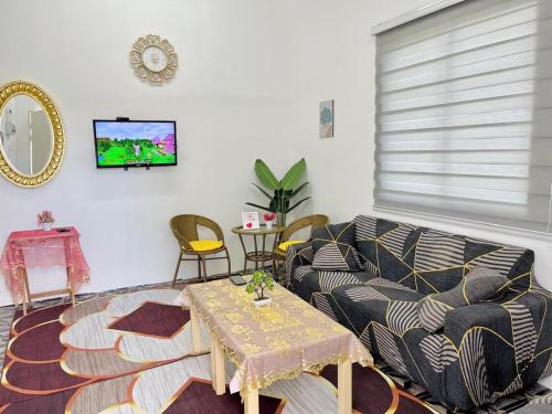 una sala de estar con un sofá y una mesa en Homestay Keboon Rantau Panjang, en Rantau Panjang