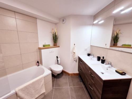 une salle de bain avec une baignoire, des toilettes et un lavabo dans l'établissement Charmant appartement au cœur de Montalbert avec balcon et parking privé, proche des pistes - FR-1-755-33, à Aime La Plagne