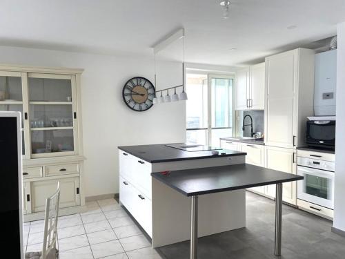 une cuisine avec une table et une horloge au mur dans l'établissement Appartement front de mer 6 pers, parking, WIFI - FR-1-790-32, à La Grande Motte