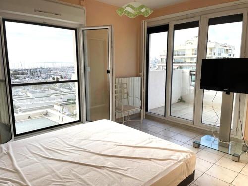 une chambre avec un lit et une télévision à écran plat dans l'établissement Appartement front de mer 6 pers, parking, WIFI - FR-1-790-32, à La Grande Motte
