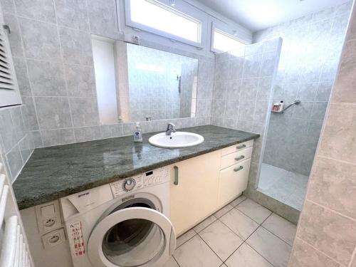 une salle de bain avec une machine à laver et un lavabo dans l'établissement Appartement front de mer 6 pers, parking, WIFI - FR-1-790-32, à La Grande Motte