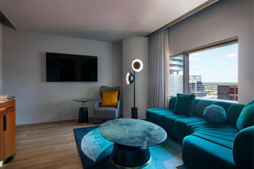 a living room with a green couch and a table at W Austin in Austin
