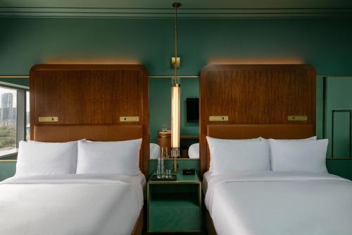 two beds in a room with green walls at W Austin in Austin