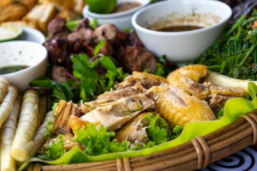 a plate of food with meat and vegetables on a table at Truong Nhan Tram Tau Homestay in Cham Ta Lao