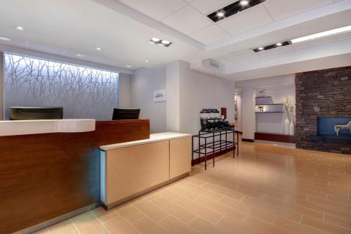 a waiting room with a counter and a fireplace at Fairfield Inn and Suites by Marriott Rochester West/Greece in Rochester