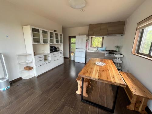 a kitchen with a wooden table in a room at ココナッツ屋久島 in Yakushima