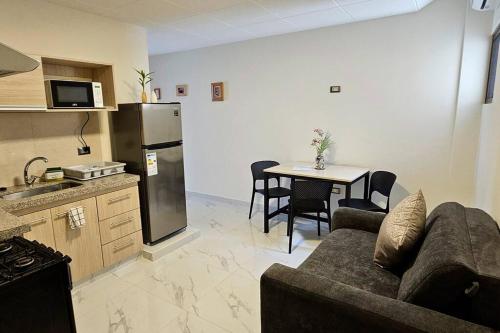 a kitchen and a living room with a couch and a table at C 1 - Cálido depto Edif Alfas cambio paralelo in Tarija