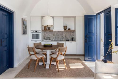a kitchen with blue doors and a table and chairs at Vedema, a Luxury Collection Resort, Santorini in Megalokhori